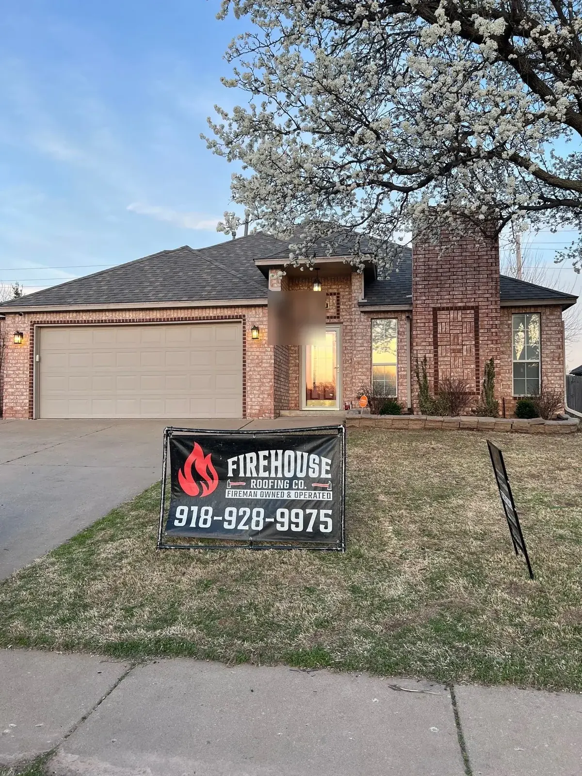 FireHouse Roofing yard sign in front of a Bixby roof replacement with a brick home and chimney