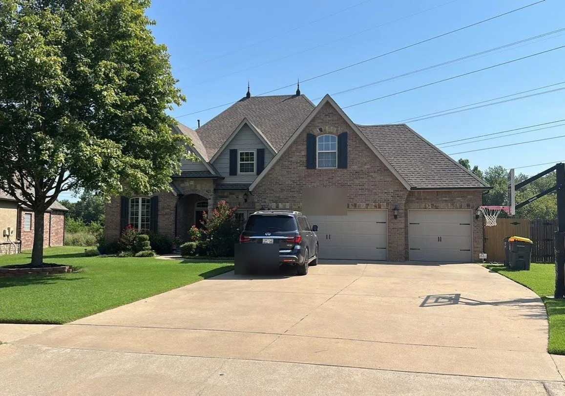 Completed roof replacement on a large Bixby brick home with steep roof lines