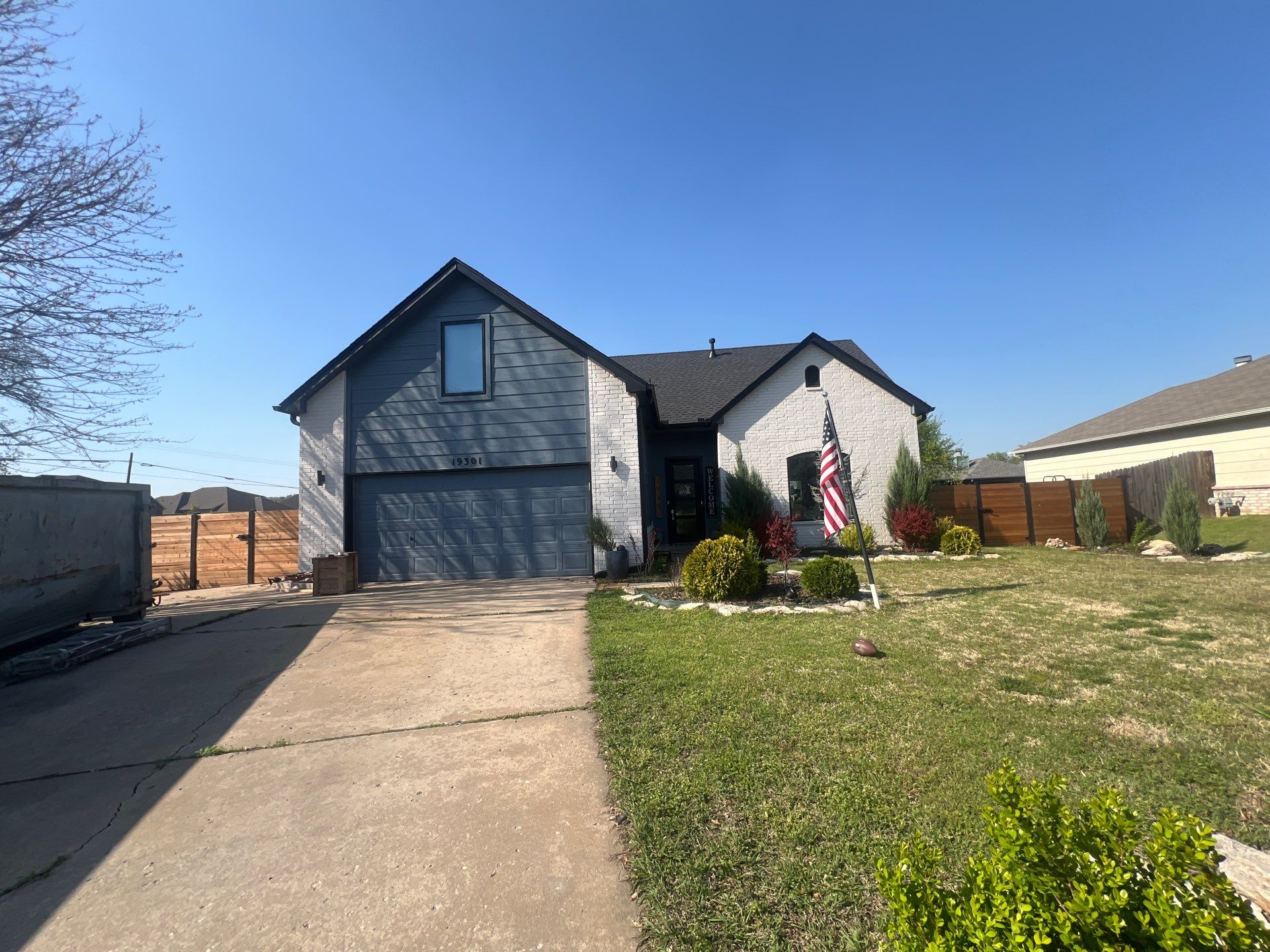 Completed FireHouse Roofing roof replacement on a Catoosa modern blue and white home
