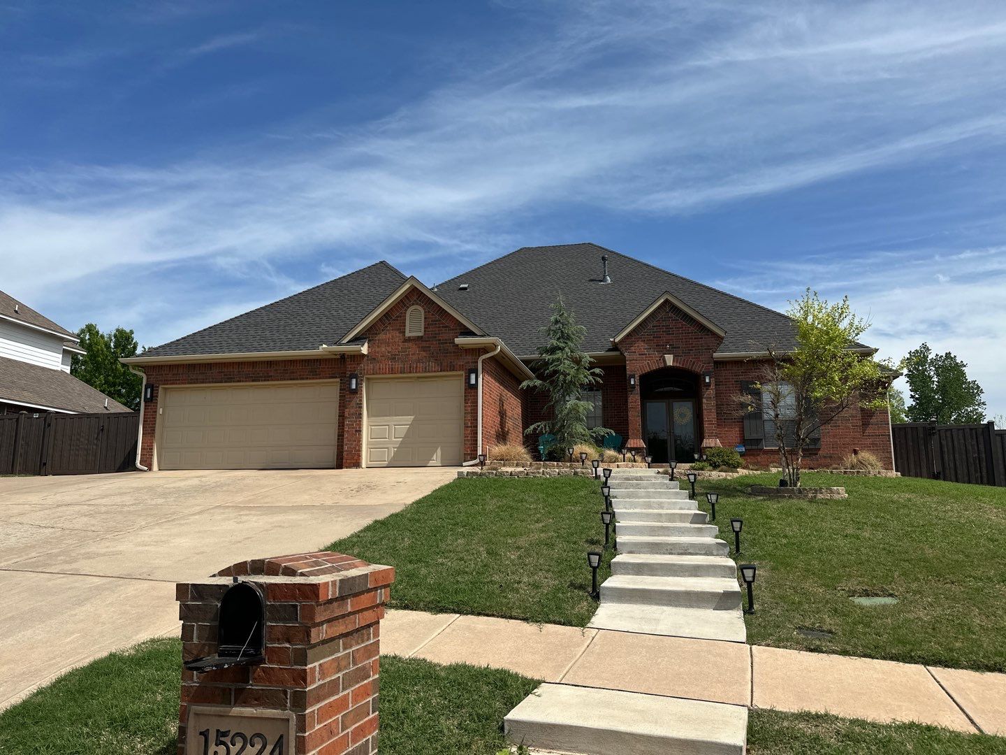 Completed FireHouse Roofing roof replacement on a large brick home with dark architectural shingles