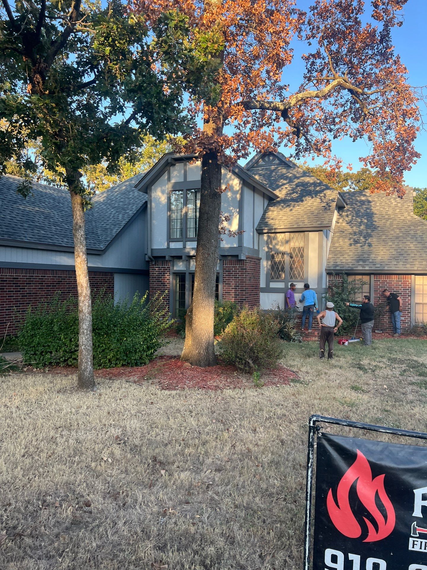 FireHouse Roofing crew on a Sapulpa brick and stucco Tudor-style home during a roof replacement project