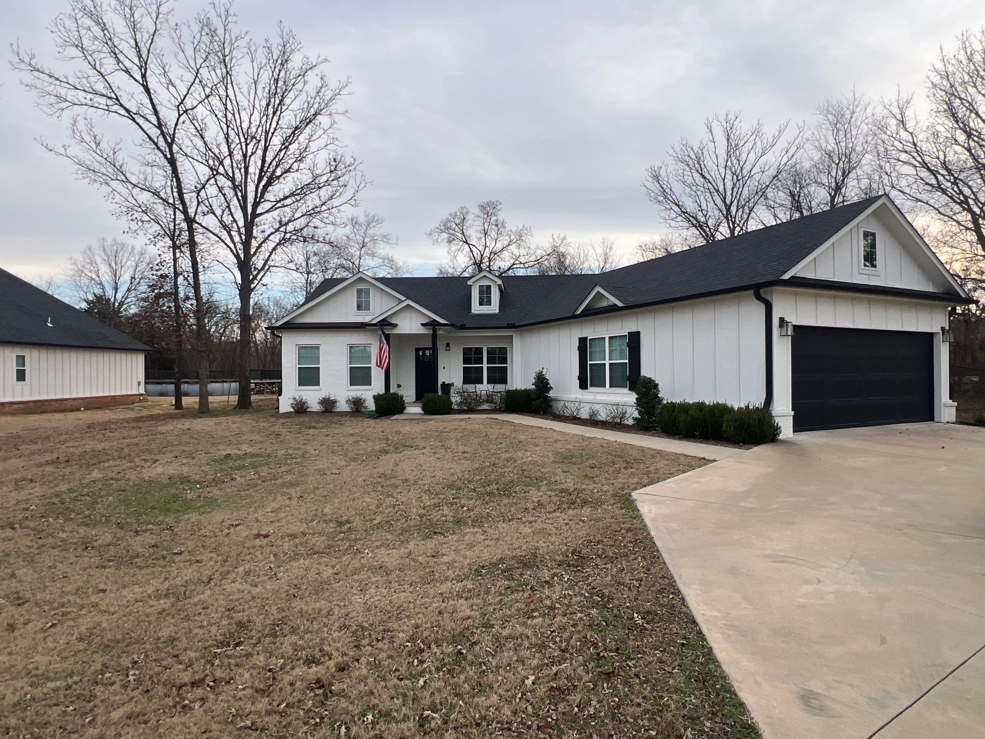 Completed roof replacement on a Sapulpa white modern farmhouse with dark architectural shingles
