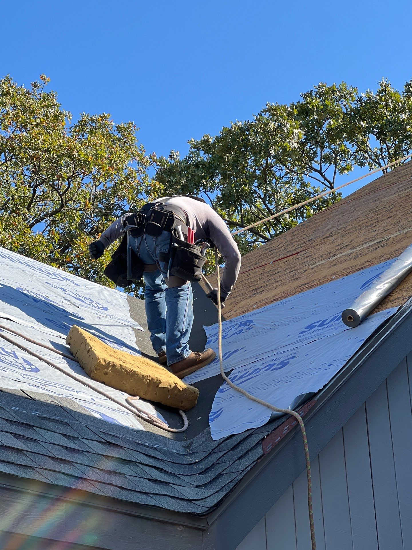 FireHouse Roofing installer fastening fresh decking and synthetic underlayment on a Sapulpa roof replacement