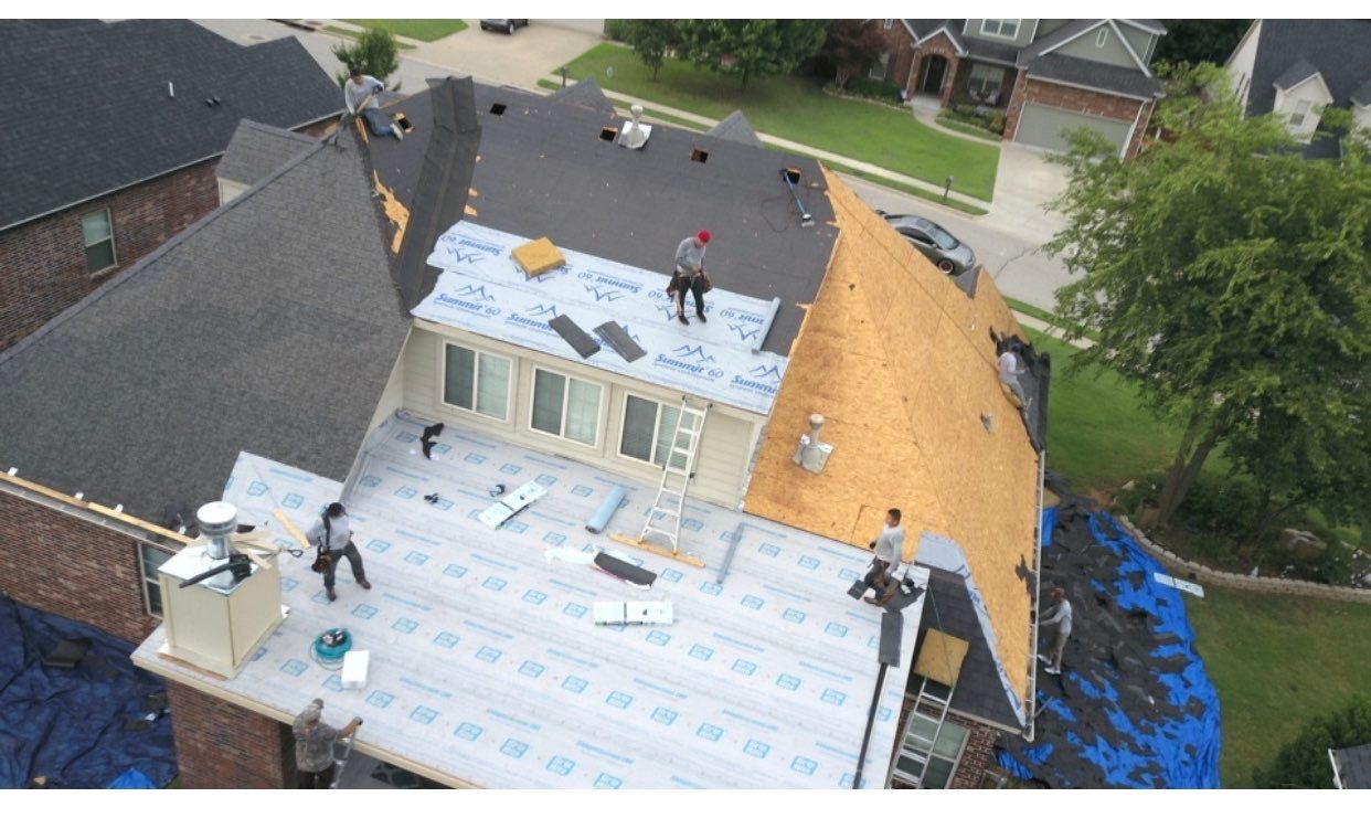 Aerial view of FireHouse Roofing crew installing underlayment on a Sand Springs roof replacement