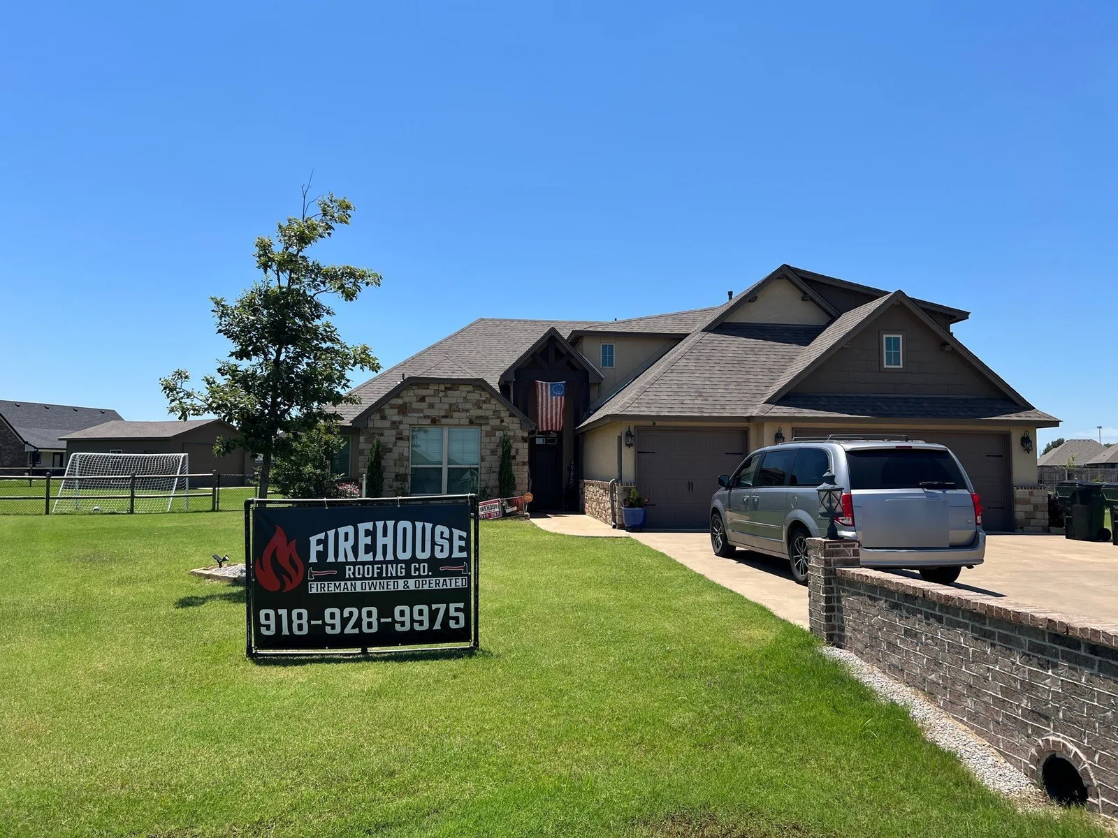 Stone and stucco craftsman-style Collinsville home with new architectural shingle roof and FireHouse Roofing yard banner