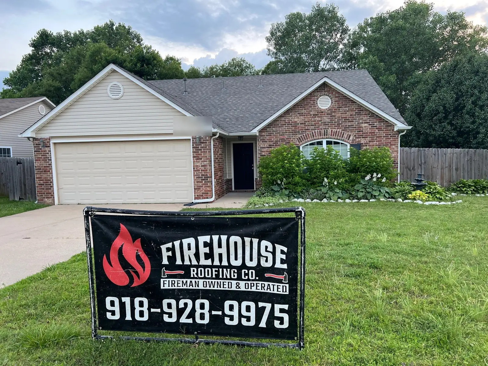 Completed FireHouse Roofing roof replacement on a Broken Arrow home with FireHouse yard banner