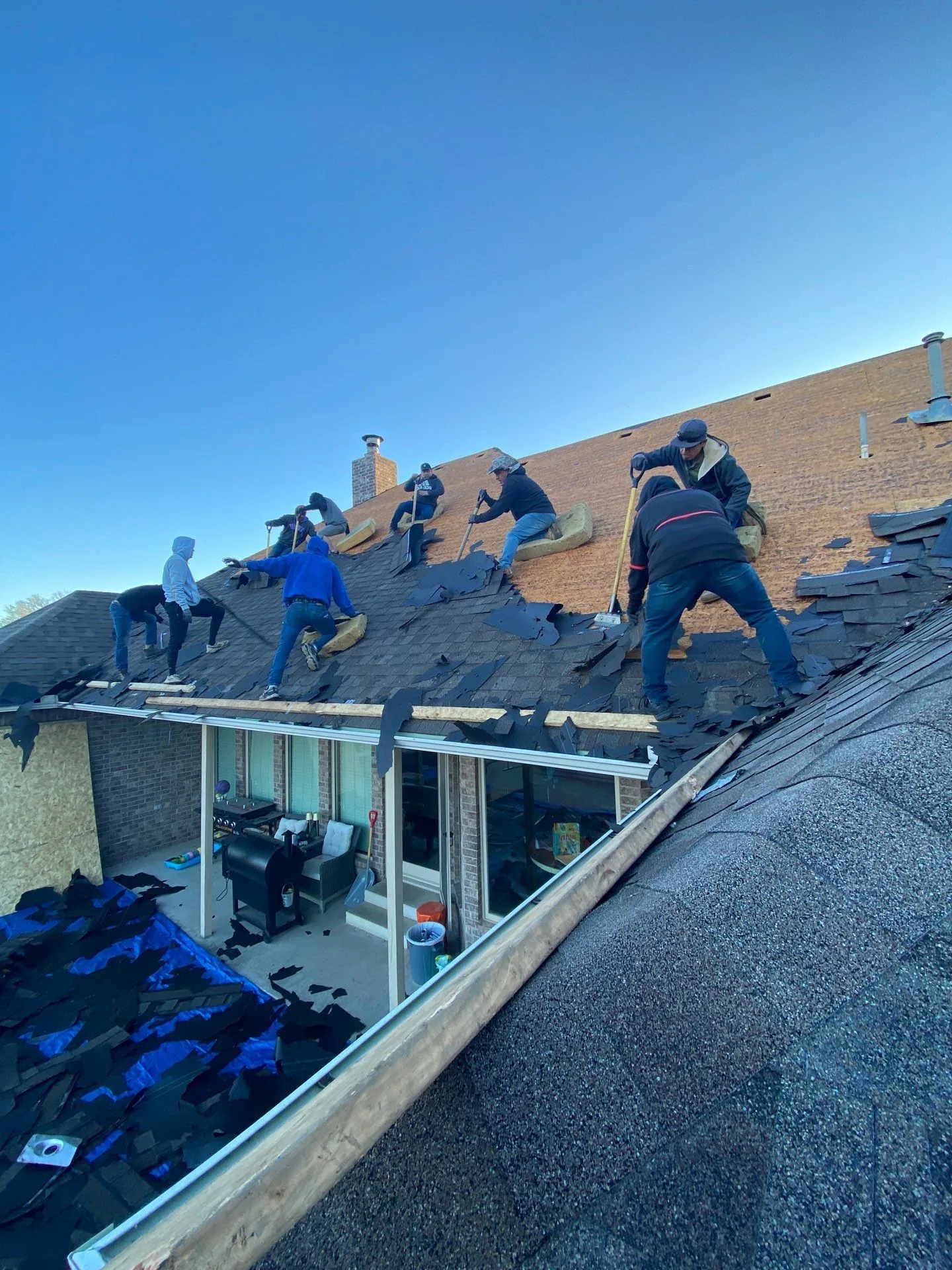 FireHouse Roofing crew tearing off shingles during a Claremore roof replacement
