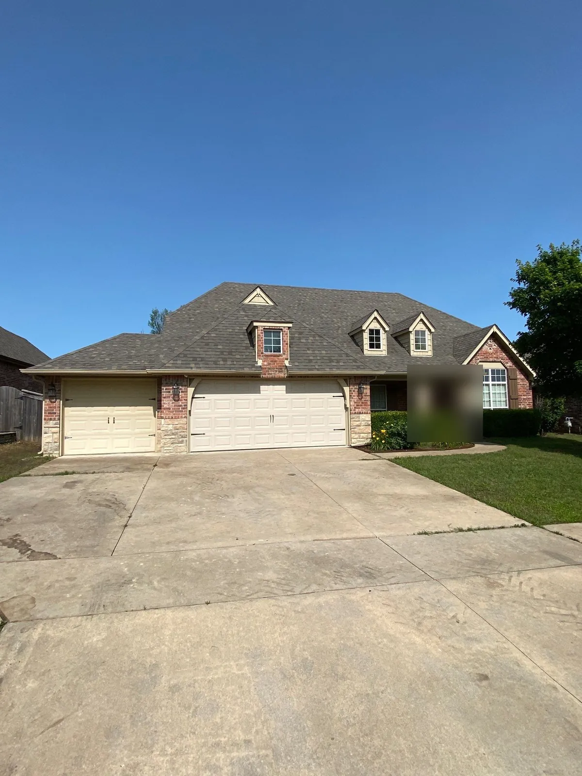 Completed FireHouse Roofing roof replacement on a Bixby brick and stone home with dormers