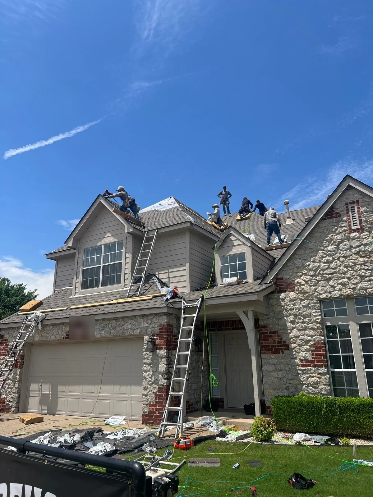 FireHouse Roofing crew installing a new roof on a Broken Arrow stone and siding home